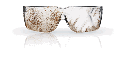 A pair of safety glasses covered in dirt and grime, partially obstructing visibility.